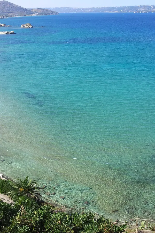 The crescent-shaped sandy beach and calm turquoise waters of Kera beach in Crete, Greece.
